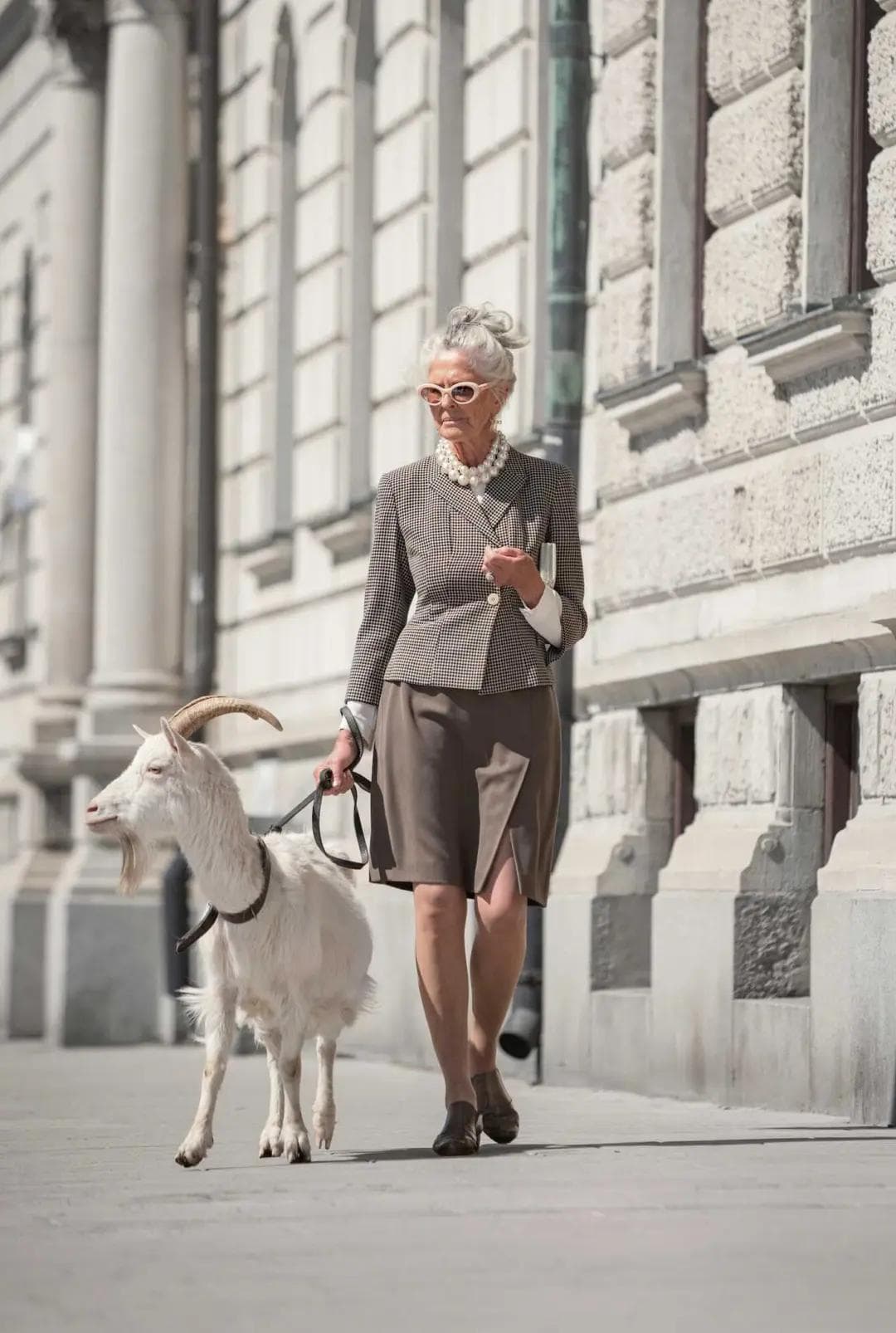 Elegant senior model in vintage suit, street fashion scene with goat – book mature talent for stills and commercials with Synk Casting, Sweden.
